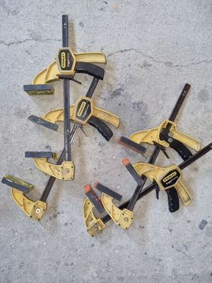 Plusieurs outils sont disposés au sol, sur une surface en béton.