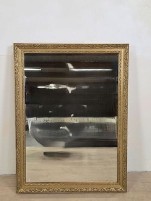 miroir à cadre doré avec un bol au centre