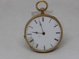 a small gold pocket watch with roman numerals on it