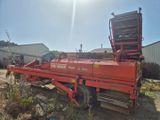 un camion rouge garé sur la terre battue