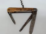 un petit couteau avec un manche en bois posé sur une surface blanche