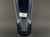 un vase en verre muni d'une étiquette, posé sur une table