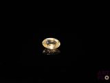 a yellow sapphire stone on a black surface
