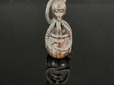 un gros plan sur une figurine représentant une femme tenant un serpent