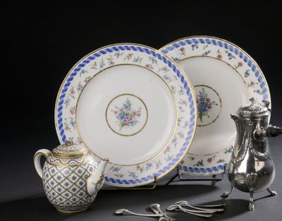 deux assiettes et une théière en argent posées sur une table