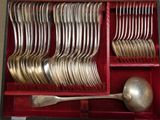 des couverts dans un étui rouge, avec une cuillère et un repose-cuillère