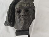une sculpture représentant la tête d'une femme posée sur un socle