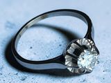 une bague sertie d'un diamant, posée sur une table
