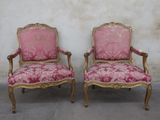 pair of pink and gold chairs with floral upholstered cushions