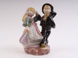 une figurine d'un garçon et d'une fille se tenant par la main