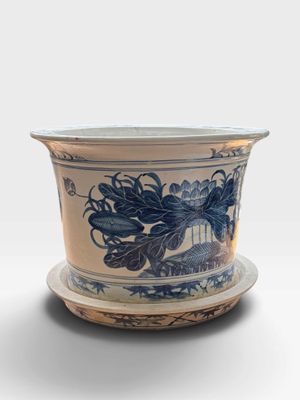a blue and white flower pot with a saucer on it