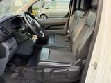 the interior of a white van with the door open and the driver ' s seat down