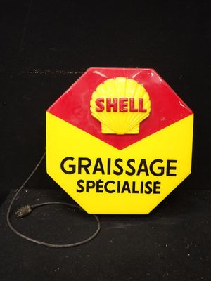 un panneau jaune et rouge sur lequel on peut lire « Graissage Spécialisé »