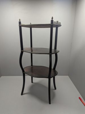 une photo d'une étagère à trois niveaux placée dans un coin