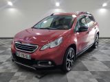 la voiture rouge est garée sur un sol en damier dans le garage