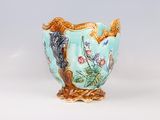 a blue vase with a bird and flowers on it