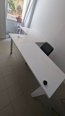 un bureau blanc avec une chaise noire dans une pièce