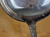a silver spoon with a black handle on a table