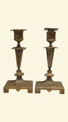 pair of antique brass candlesticks with ornate designs on bases