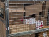 a cage with boxes on top of it in a warehouse