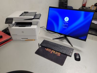 un bureau d'informatique équipé d'un écran, d'un clavier, d'une souris et d'une imprimante
