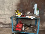un chariot de chantier bleu chargé d'outils, devant un mur de briques