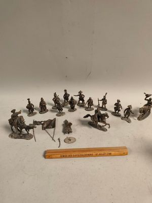 de nombreuses figurines de soldats et un crayon sur la table