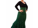 a woman wearing a green skirt and black top