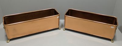 two metal containers sitting on top of a white table