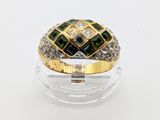 an image of a diamond and emerald ring on a clear surface