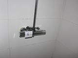 a toilet with a roll of toilet paper attached to the wall