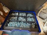 a box of screws and nuts in it on the floor