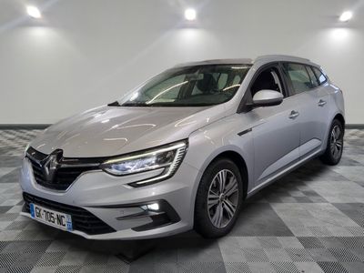 une voiture argentée est garée dans une grande pièce au sol en damier
