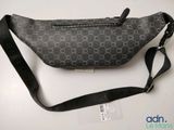 a close up of a black and white fanny bag on a table