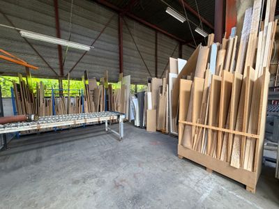 de nombreuses pièces de bois empilées sur une palette dans un entrepôt