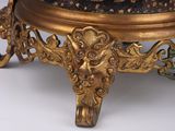 an ornately decorated bowl sitting on top of a gold stand