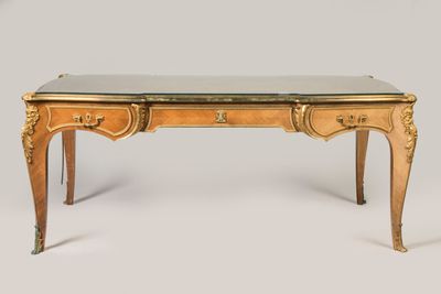 un bureau ancien avec un plateau en verre et des finitions dorées