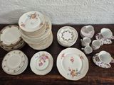 many plates and cups sitting on a wooden table