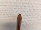 a close up of a wooden stick sticking out of a wall