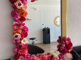 a mirror that has flowers on it on the wall