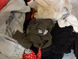 a pile of clothes sitting on top of a bed