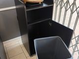 une poubelle posée à côté d'une autre poubelle, par terre