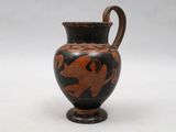 a black and red vase sitting on a white surface
