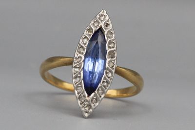 Bague navette en or sertie d’une pierre et de diamants.