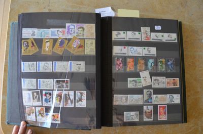 une personne tenant un livre sur lequel sont apposés des timbres