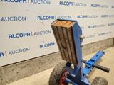 a blue hand truck with a wooden block attached to it
