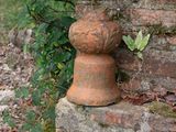 un vase en pierre posé au sommet d'un mur de briques