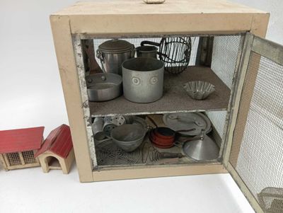 un petit placard contenant des casseroles et des poêles