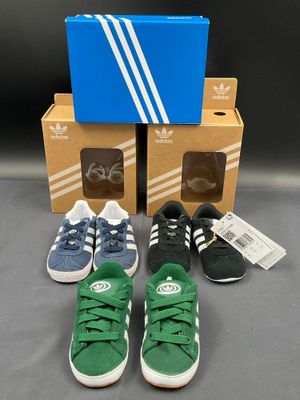 three pairs of adidas shoes and a box of shoes