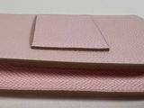 two pink purses sitting on top of each other on a table